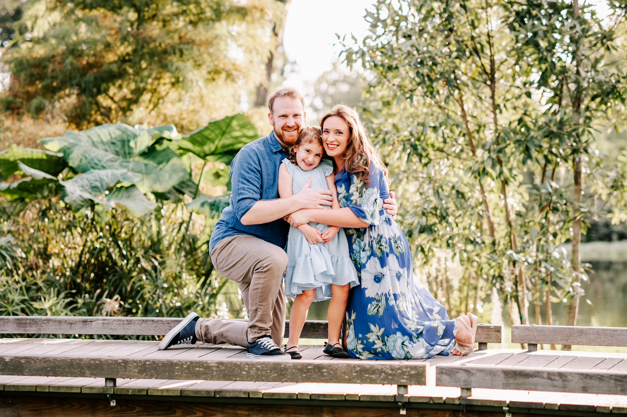 A happy family of three hug and snuggle while on a boardwalk before visiting north carolina fall festivals