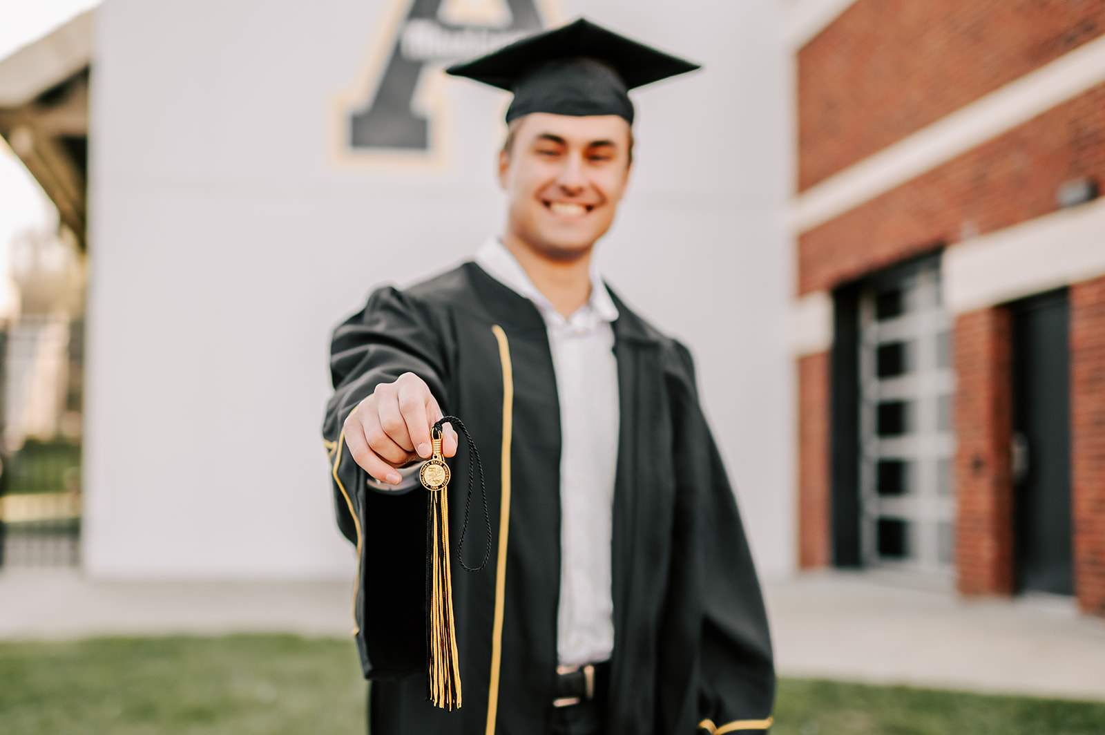 Details of a tassel being held by a grad while wearing cap and gown